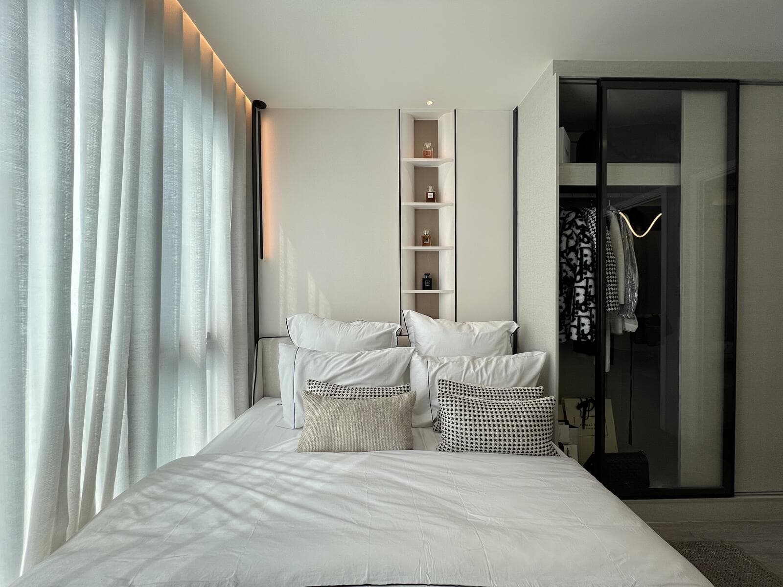 Sleeping area of a 25.80 sq.m. one-bedroom show unit at Atmoz Oasis Onnut, with a double bed, recessed shelf niche and a mirrored sliding-door wardrobe