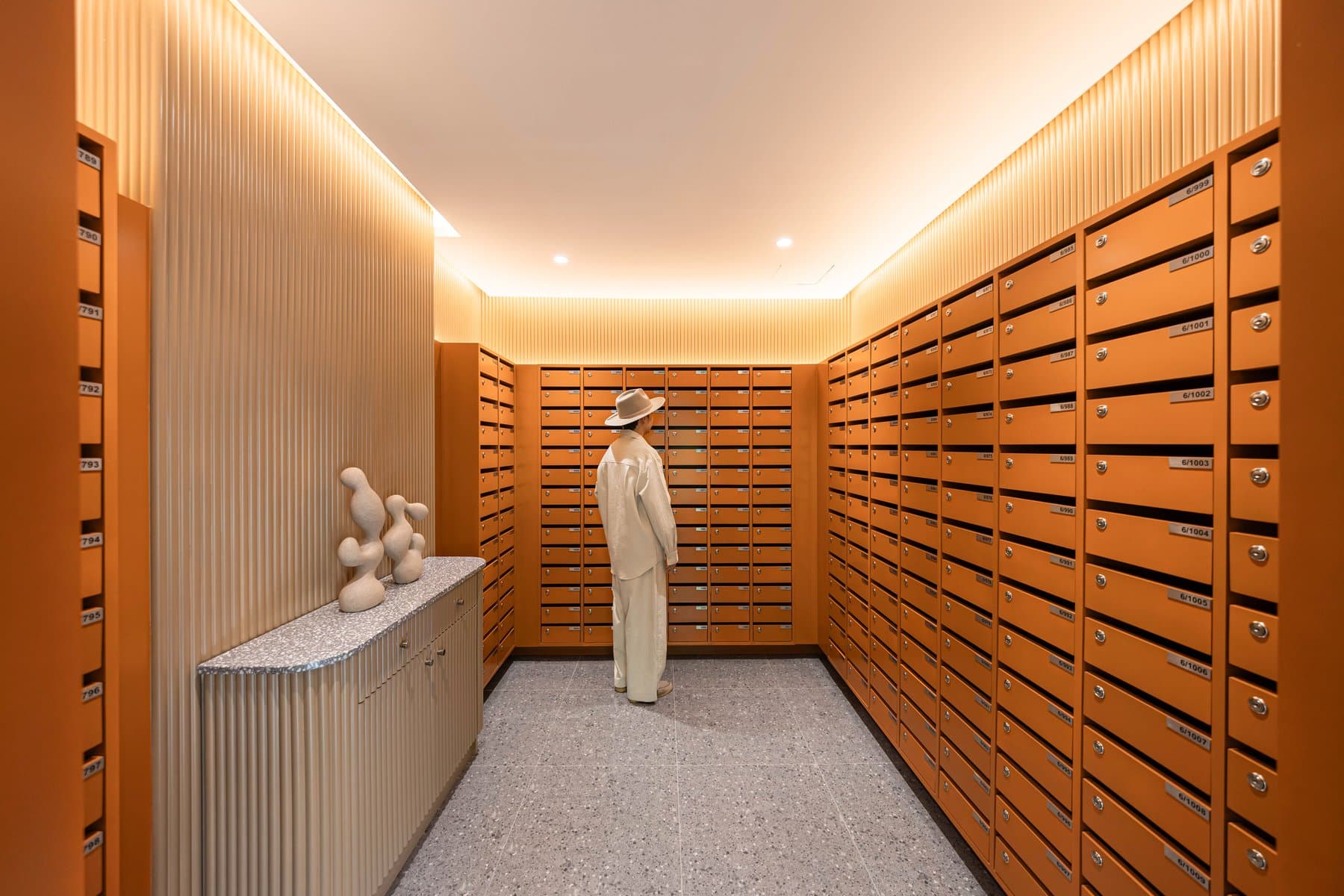 Parcel and mail room at Kave COCO Bangsaen, lined floor to ceiling with timber lockers under a warm cove-lit ceiling