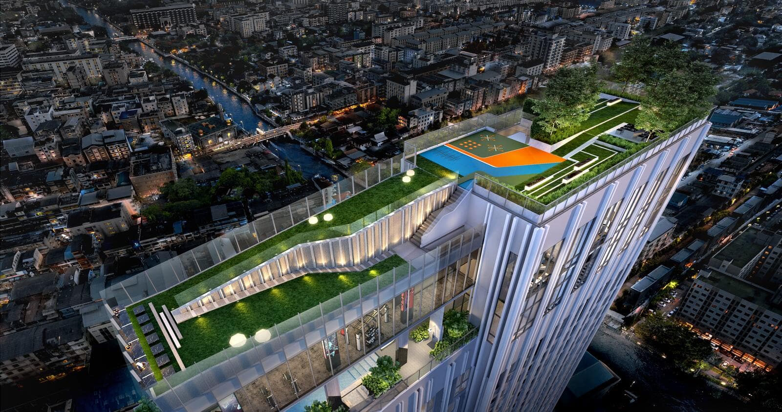 Aerial dusk view of the rooftop cloud facilities at Modiz Rhyme Ramkhamhaeng, showing the tiered sky lawn, a coloured multi-use court, swimming pool and garden terraces above the tower with the lit Hua Mak neighbourhood and canal below (computer-generated render)