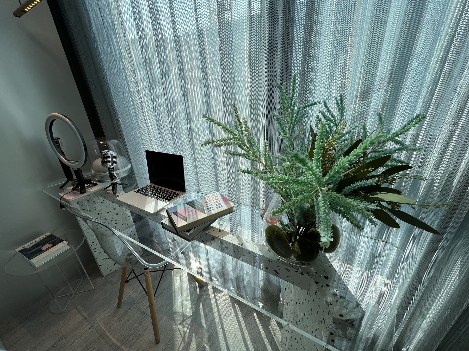 Marble-topped work desk in a furnished show unit at Atmoz Oasis Onnut, with a ring light, a monitor and a large fern beside the window